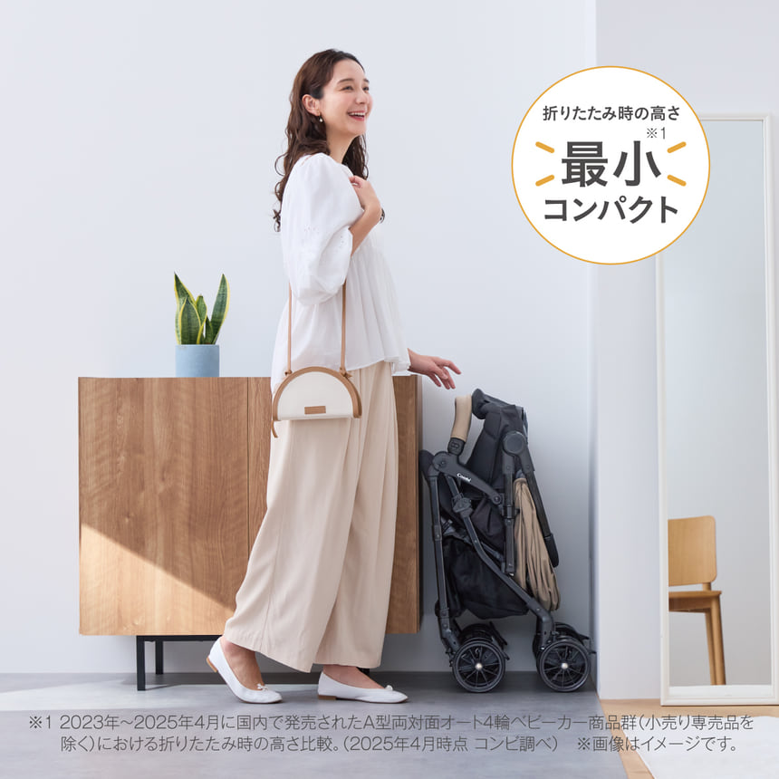折りたたみの高さ最小コンパクト。コンパクトに折りたたまれたスゴカルLを室内で見せるママ。収納性の高さが伝わるシーン。