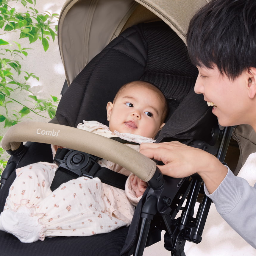 パパと見つめ合う赤ちゃんの笑顔。スゴカルLの安心安全な乗り心地を伝える心温まるシーン。