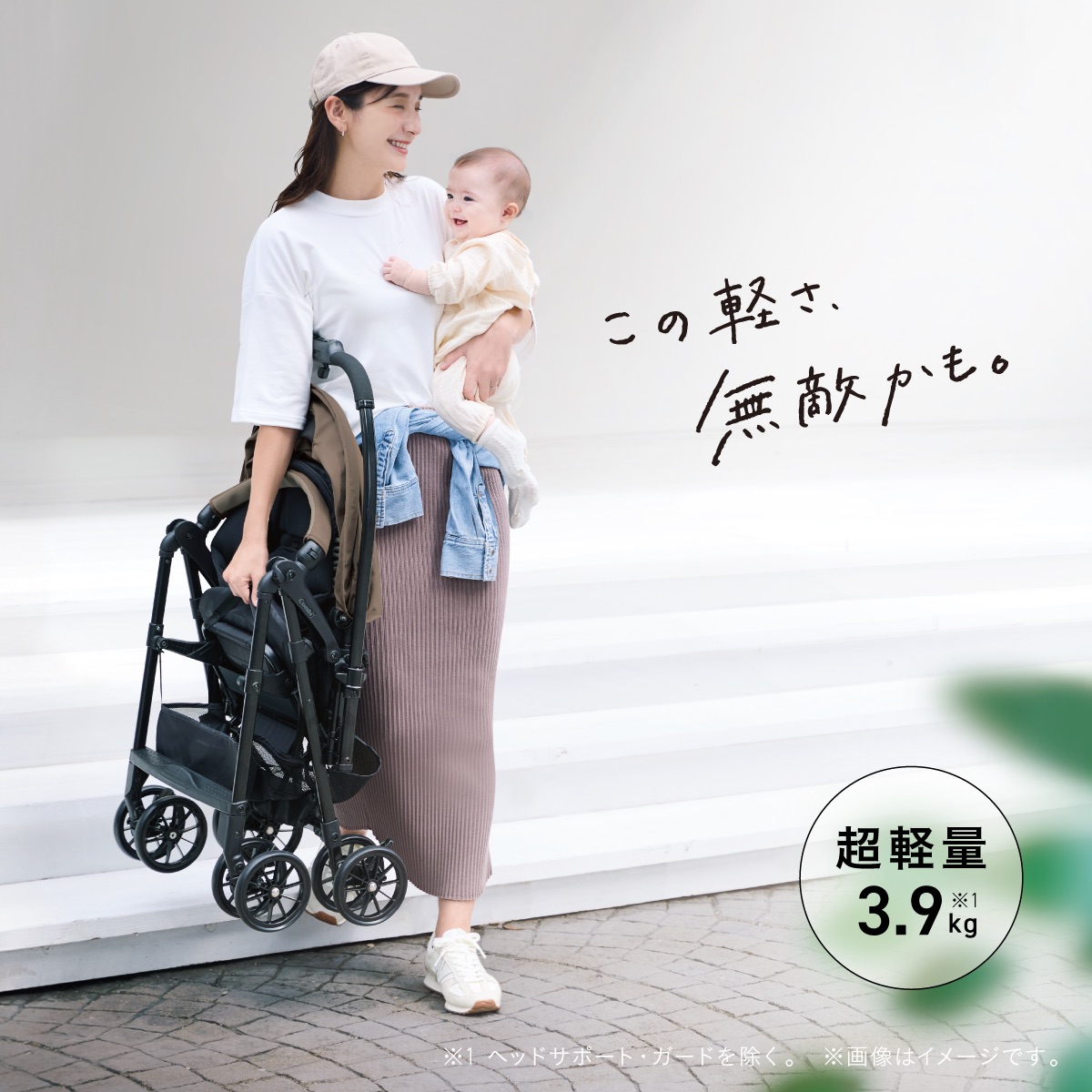 コンビの超軽量ベビーカー「スゴカル」の軽さを表現したイメージ。赤ちゃんを抱っこしながら、折りたたんだベビーカーを片手で軽々と持つママ。ヘッドサポート・ガードを除いた本体重量はわずか3.9kg。「この軽さ、無敵かも。」のキャッチコピーとともに、赤ちゃんとのお出かけを快適にする持ち運びやすさを訴求。