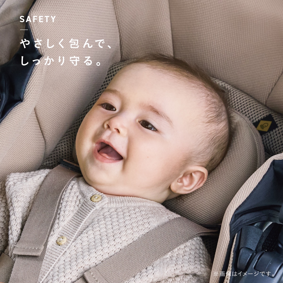 ベージュのクッションにやさしく包まれ、笑顔を見せる赤ちゃん。頭部を支えるクッションとシートベルトで、赤ちゃんをやさしく包んでしっかり守る。